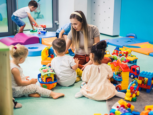 Femme qui joue avec des enfants en garderie